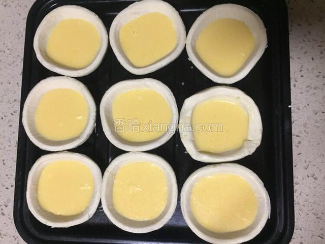 蛋挞液装入蛋挞皮七分满放在烤盘上
