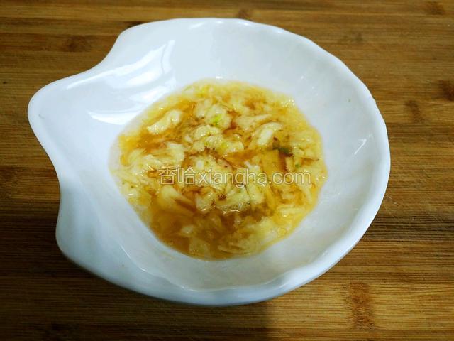 趁着蒸榆钱的功夫准备榆钱蒸菜的拌料，把大蒜去皮后放适量的盐，捣成蒜泥，多放一些香油待用