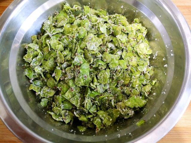 10分钟时间到立即关火揭盖，把榆钱倒进一个干净的盆子里，待榆钱稍凉后把蒜泥倒进去搅拌均匀