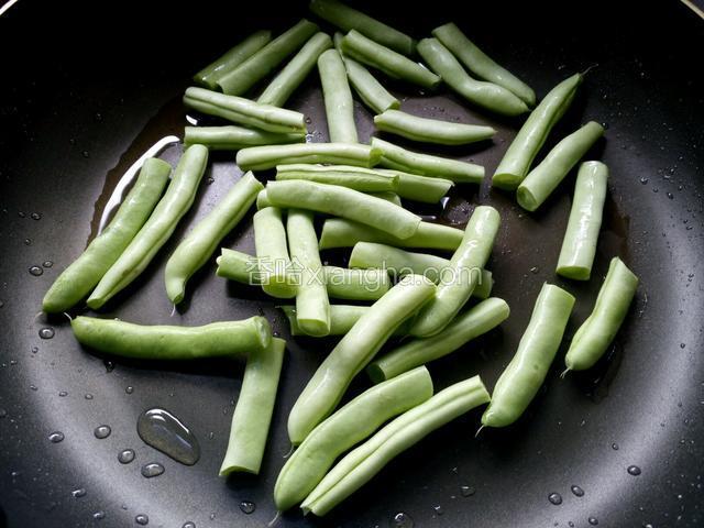 锅内留底油，放入豆角煸炒。