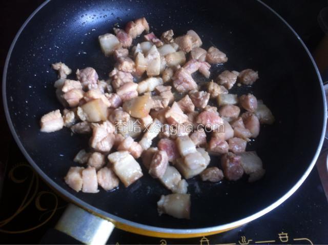 然后放入腌制的肉丁炒至变色