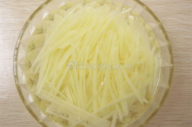 焯熟的土豆丝放入凉开水中冲洗。