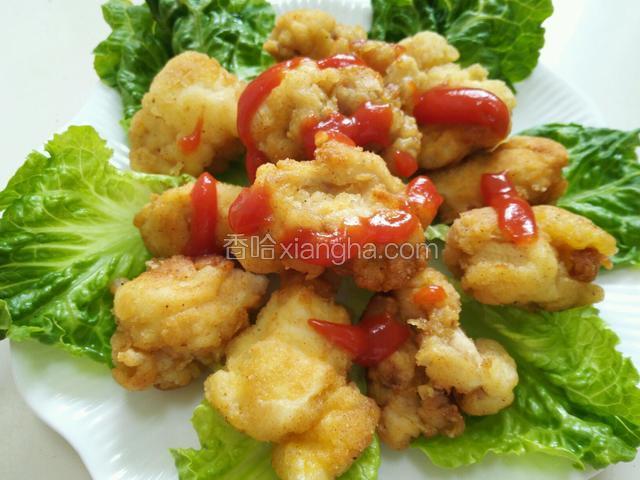 将鸡块装盘底下铺好生菜，挤上番茄酱