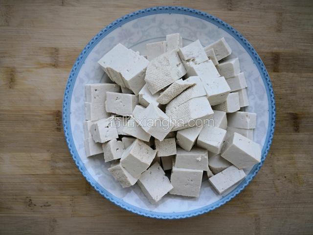 豆腐切块，装盆加水、加盐，浸泡五分钟，捞出装盘待用。