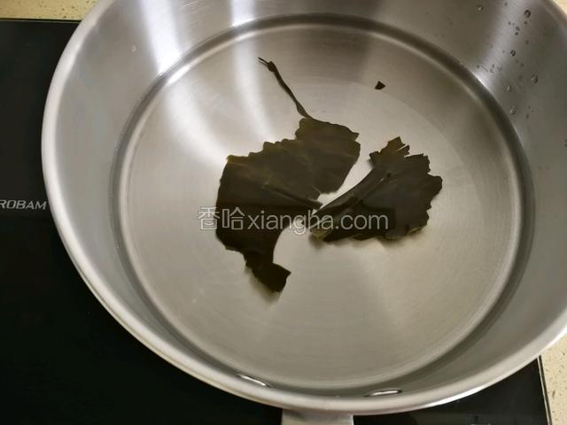 海带用湿棉布擦干净上面的白色粉末，放入锅中同300毫升水煮沸，小火十分钟关火。