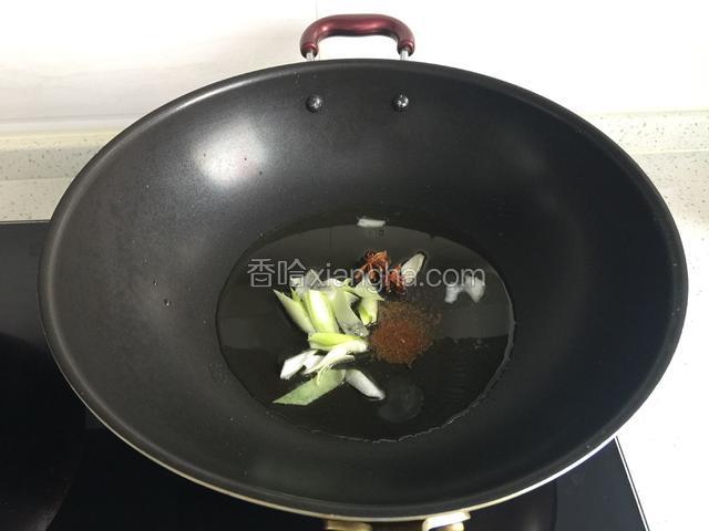 锅中倒植物油、猪油烧热，放入葱段、八角、十三香炒香。