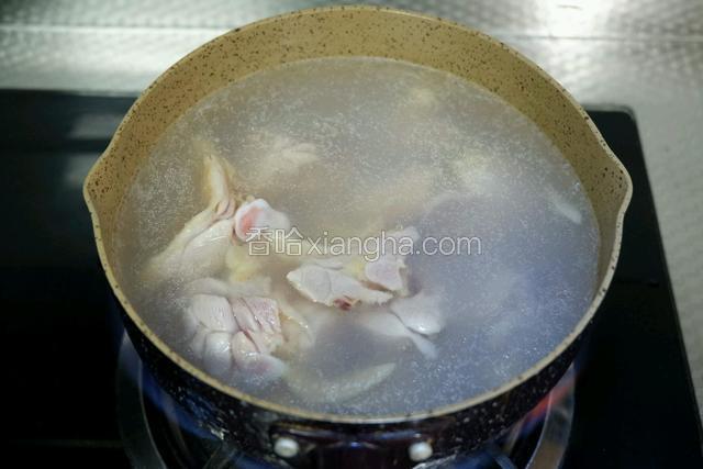 锅中加入料酒煮沸水，下鸡腿焯水
