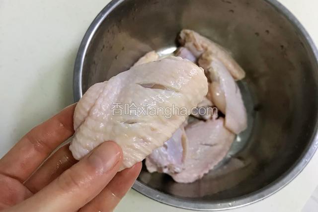 为了让鸡翅更好更快的入味，用刀把鸡翅面上划2-3刀。