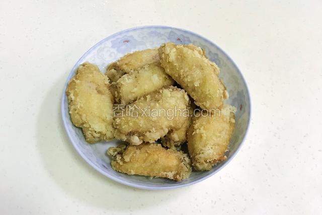 鸡翅炸至金黄色，约10分钟左右即可捞出，然后再入锅复炸一次备用。