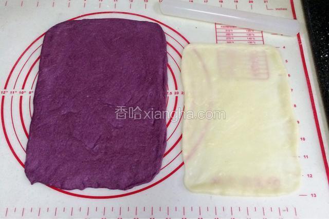 取一份松弛好的面团，用手拍扁，用擀面杖把面团擀开，翻面再擀会，用手整理成长方形，压薄底边。取一份麻薯，继续用擀面杖擀成比面片小点的长方形。