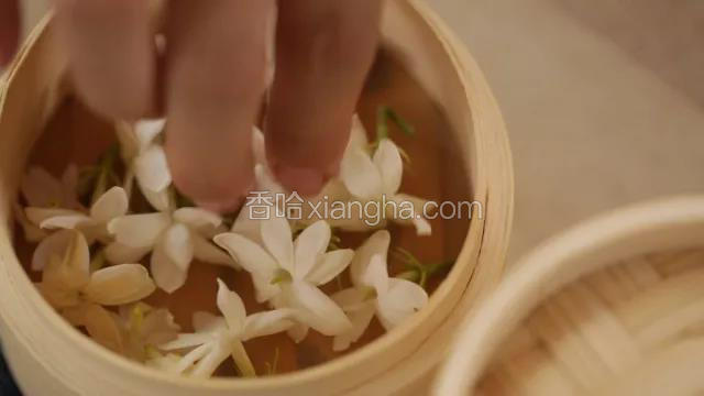 取一小竹屉，铺好油纸，再铺入新鲜茉莉花