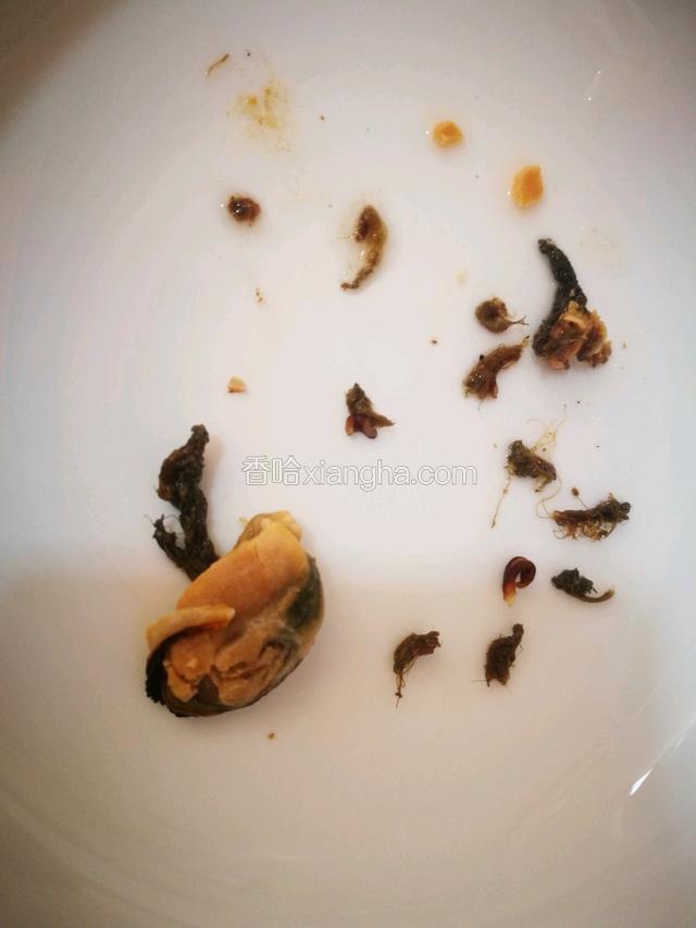 浸泡好了的淡菜，先用淘米水清洗，然后用剪刀将其肉里的腮减掉。淡菜的腮是黑色的，摸上去感觉像纤维似的。如图：
