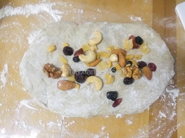 把面团放在案板上轻轻的抻开 铺上坚果 