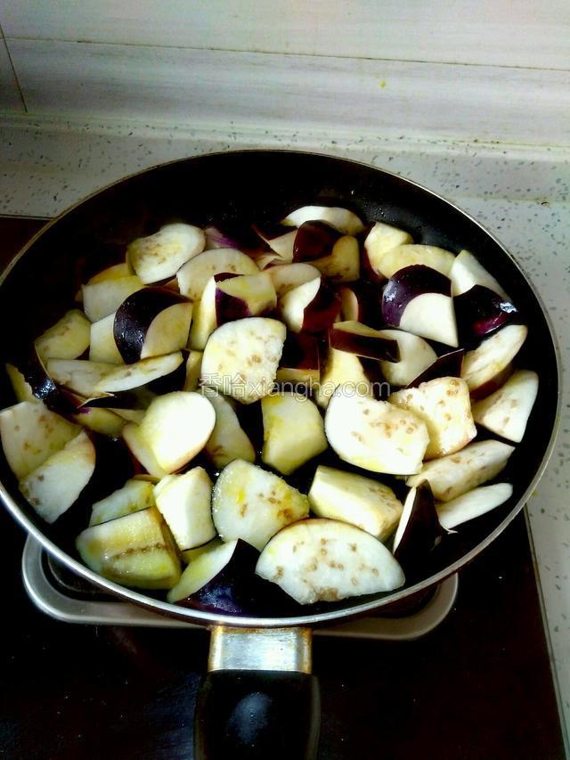 平底锅内放适量油烧热，放入茄子煎出多余的水分，变软盛出。