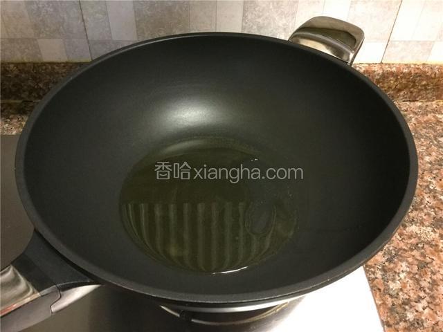 热锅倒油烧至八成热。