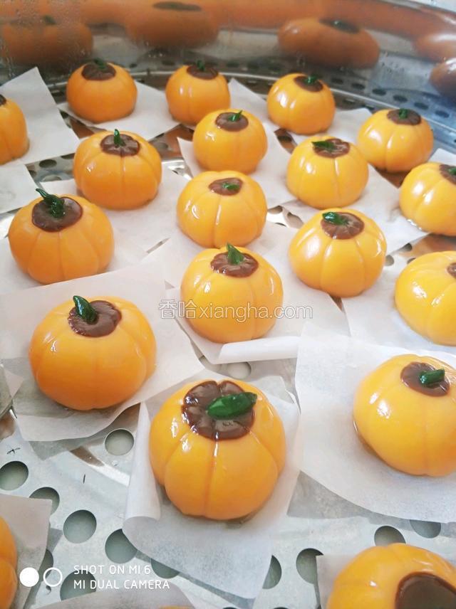 揉好的南瓜面团，取出30克-35克，包入馅心10克左右。搓圆后用棕色和绿色面团装饰，用工具压出南瓜形状