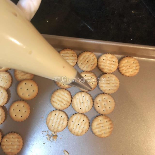 关火后糖浆在用刮刀在锅里翻拌一下，让糖体温度均匀冷却，等温度110度左右，将糖浆倒入耐高温裱花袋里挤在饼干上在盖上一个饼干