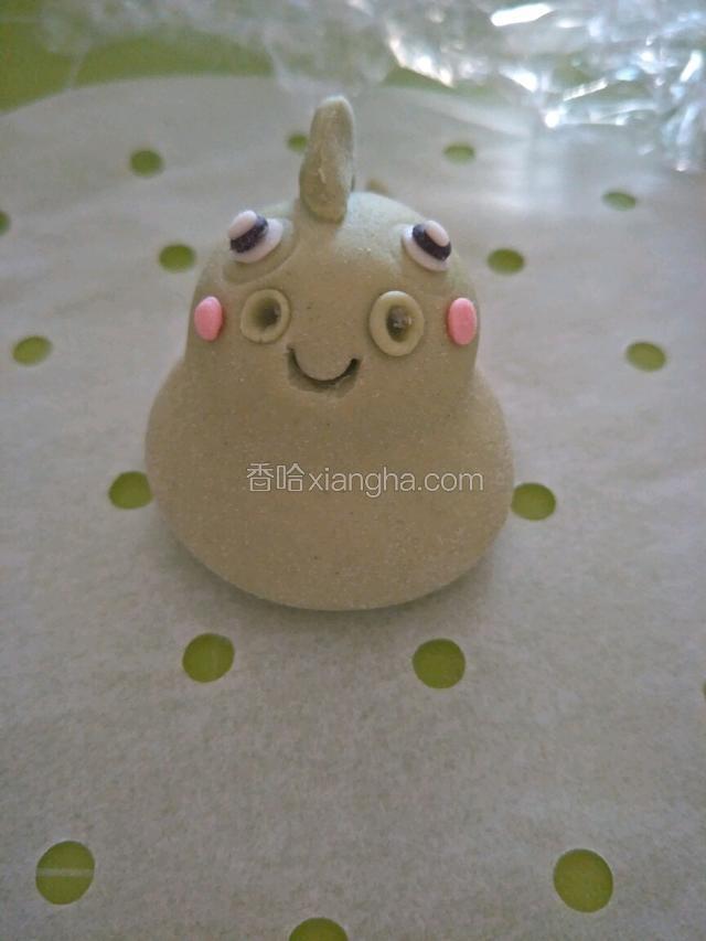 嘴的两侧上面粘两个绿色圆形点儿，用小的圆工具往里面捅一下不要太深，两侧粘上粉色腮红。