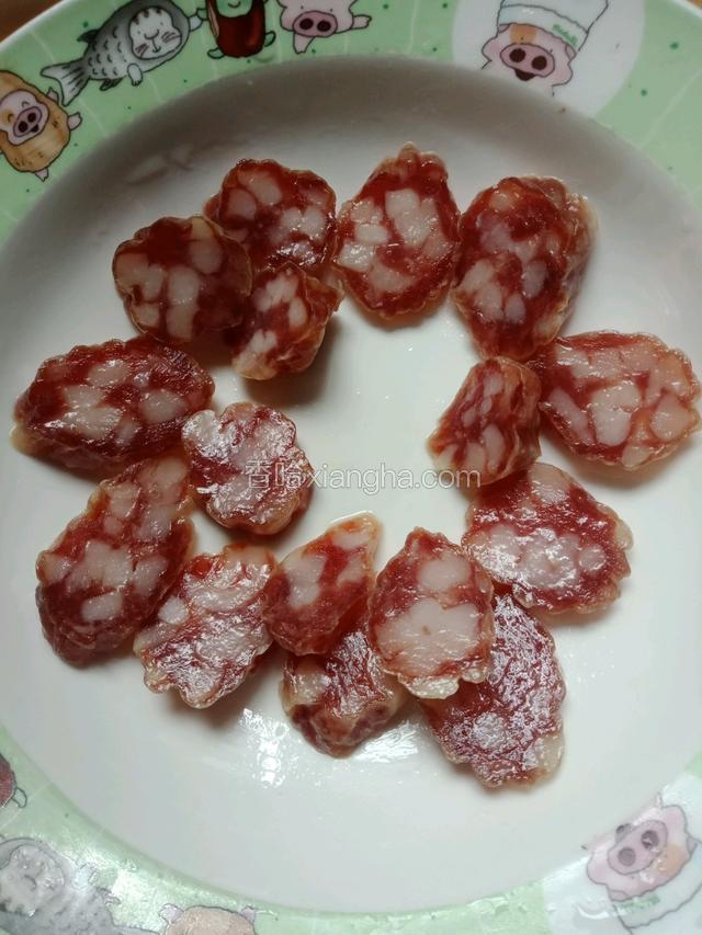 把腊肠洗干净，切片摆在盆子里，中间留出空余的地方