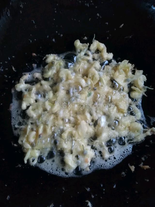 适量的油倒入锅中烧至七成热，把裹上蛋液的洋槐花一朵朵放入