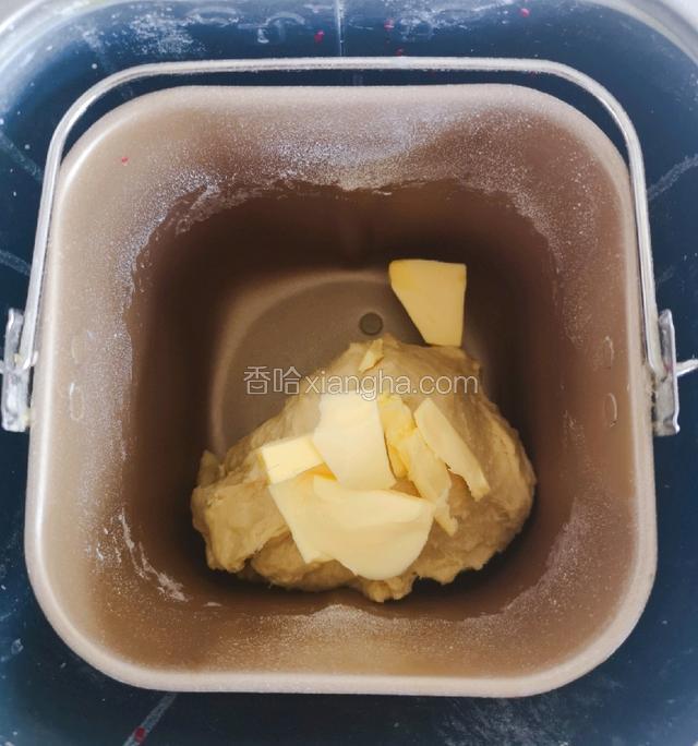 搅打约15分钟后，加入切小块的软化黄油，选择揉面功能继续搅打至可拉出薄膜。