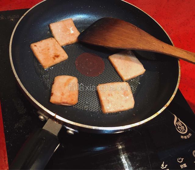 午餐肉放入平底锅煎至变色。