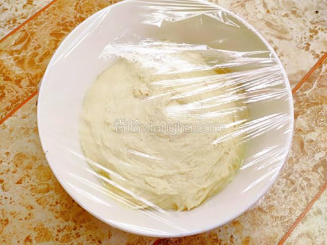 把椰子黄豆面糊盛入到蒸碗中，盖上保鲜膜，发酵两小时