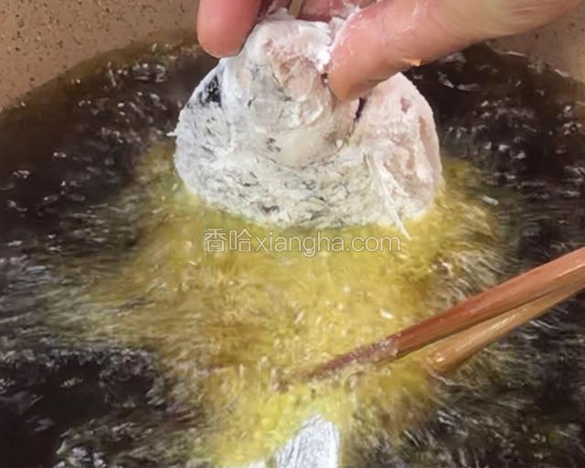 用筷子帮忙放入6成热的油锅中，炸至定型后松手