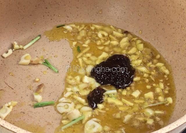 锅留底油爆香葱姜蒜，放入豆瓣酱炒出红油