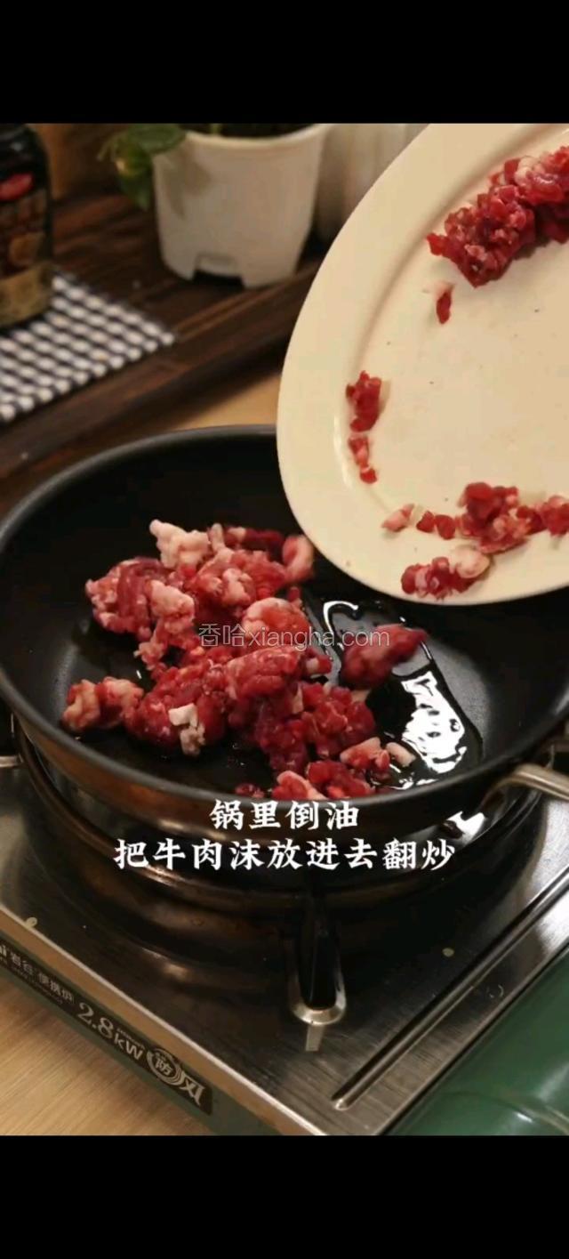 锅里倒油，放牛肉沫放进去翻炒。倒入切好的配菜。