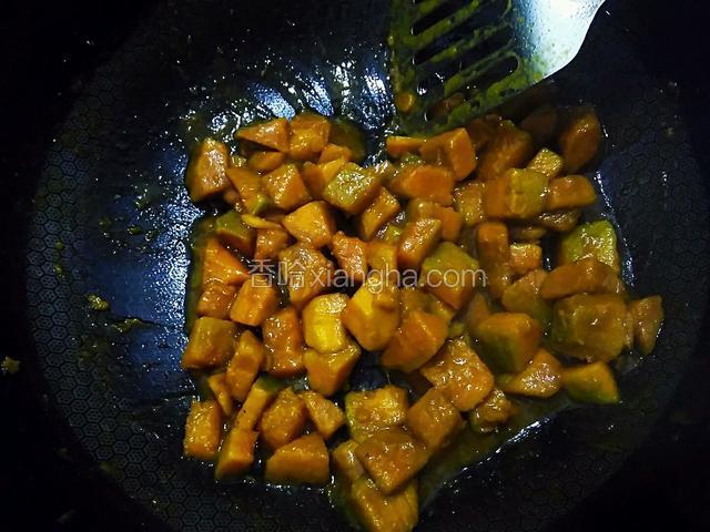 翻炒南瓜块。加一勺食盐，炒至锅中水干，南瓜变烂起糊。