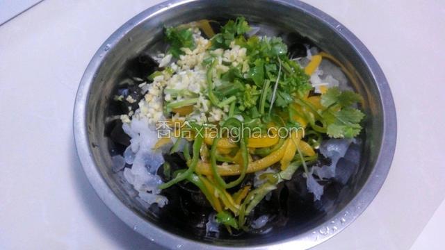 把焯好的木耳放入大点的盆中，把辣椒丝，葱丝，蒜末和香菜也放进去。