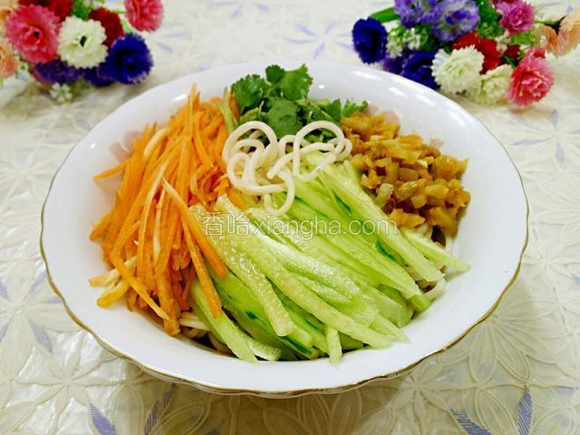 铺上黄瓜丝、胡萝卜丝、香菜、榨菜粒。