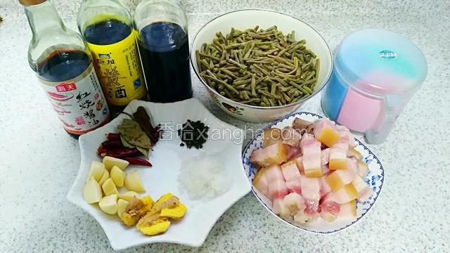 五花肉入冷水煮开五分钟捞出，切均匀块状。干豇豆泡一晚切寸段。姜拍扁备用。