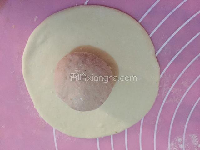 4.将发酵好的面团分成小块，白色面团擀成面饼，粉色面团揉成面团，将面团放入面饼上
