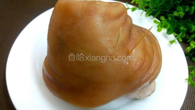 捞出煮好的猪腿肉放凉，用厨房纸擦干水份，并用牙签在肉皮表面扎许多小孔。