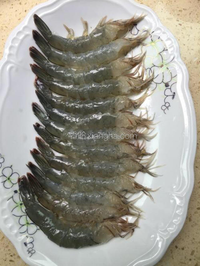 虾去头剥壳，再用刀切开虾腹部，不要切断，取出虾肠。