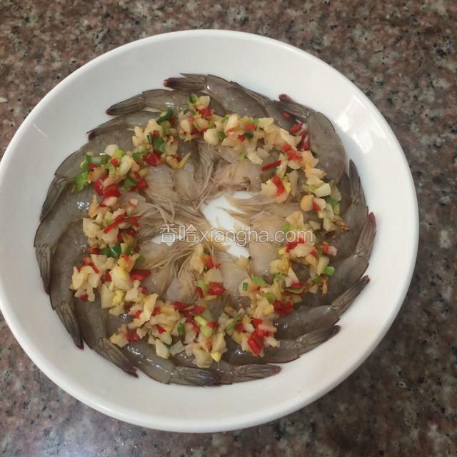 把爆好的蒜姜，青红椒粒均匀的撒在虾上。