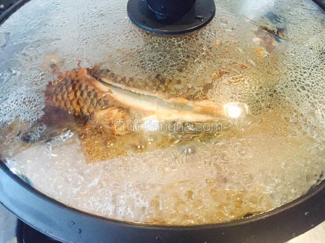 加入热水(不要超过鱼背)盖盖大火转小火焖煮8分钟(其间给鱼翻个个头)