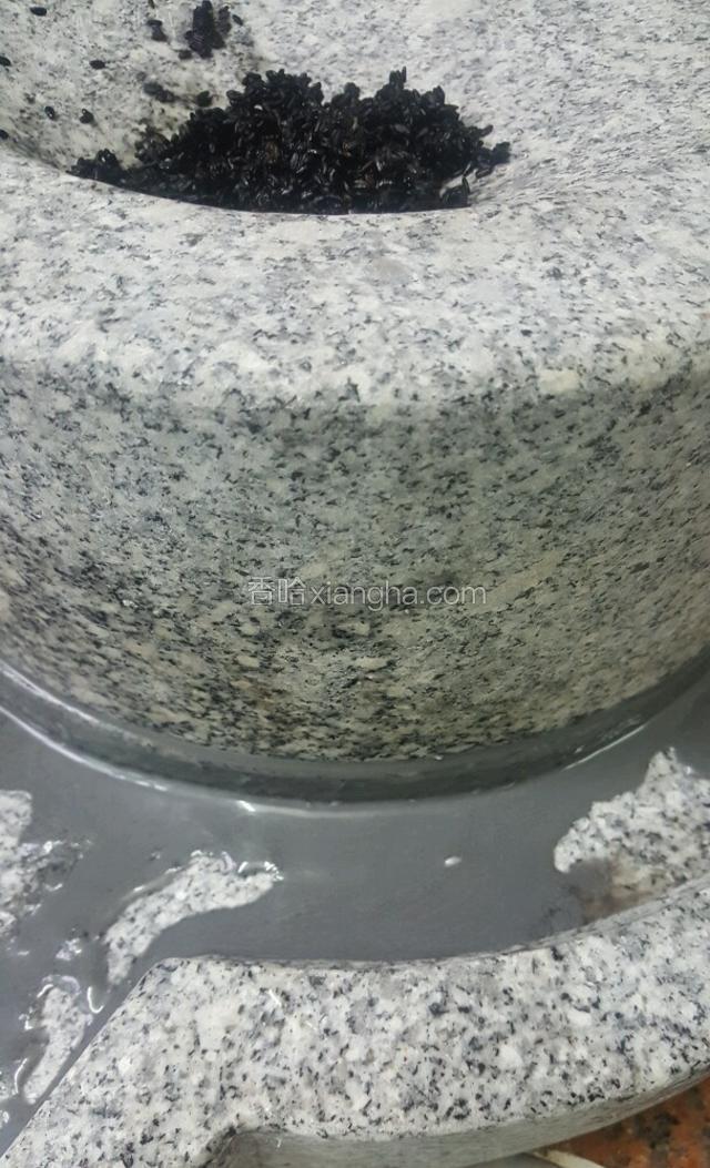 这是还没有加水的，因为本来浸泡的时候芝麻就已经吸收了些许的水份的了，先磨两轮之后再开始一勺一勺的把水加进去磨