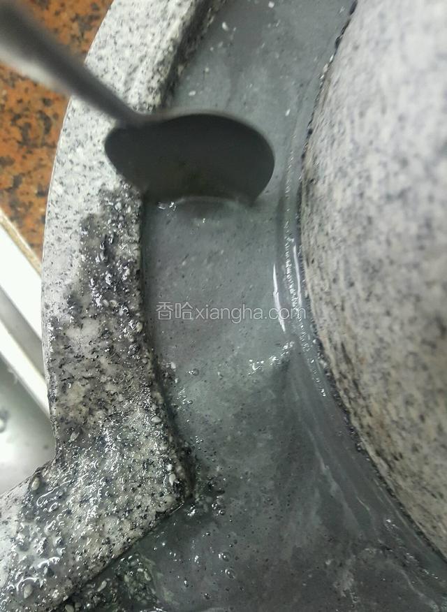 磨第一轮的时候有些芝麻还是颗粒状的，所以要借助勺子推一下才会掉入盘子里面