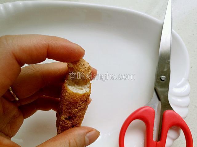 接着在炸好的豆腐块一端剪出一个小口，不要剪断。