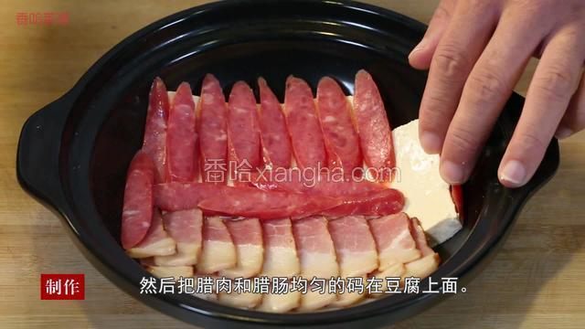 将豆腐码入砂锅底部，然后将腊肉和腊肠均匀码放在豆腐上。