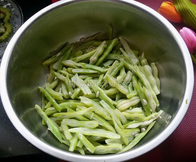 豆角热水煮熟，煮3-5分钟，然后再斜刀切成丝。