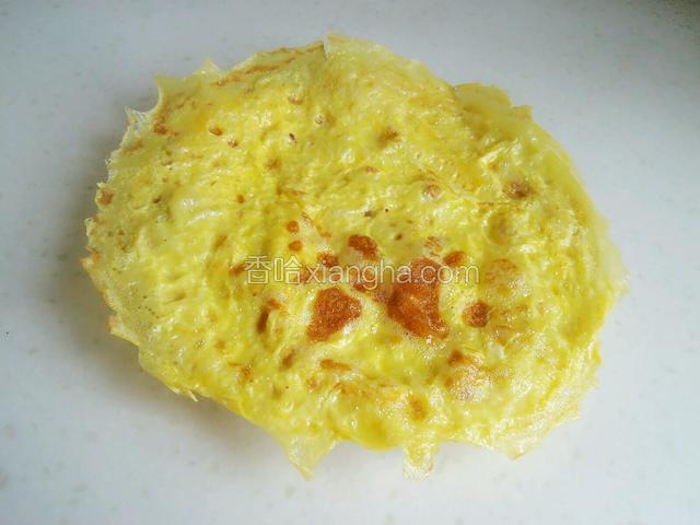 一个鸡蛋饼就摊好出锅了，继续把第二个鸡蛋打入碗里，同样朝着一个方向搅散，然后摊第二个鸡蛋饼。
注：稍微晾凉一些再切。