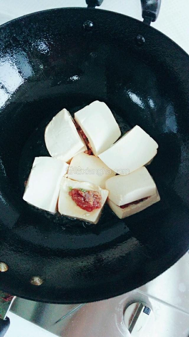 油温不要太热将豆腐夹放入，小火慢煎