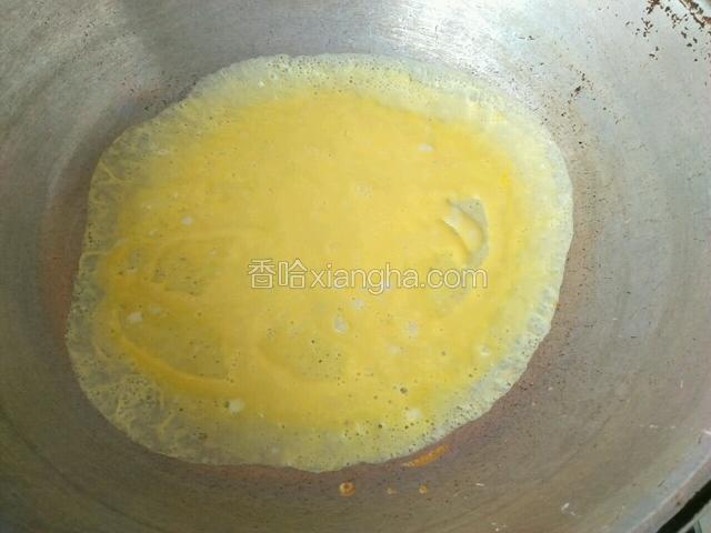 倒入鸡蛋液之后，端起炒锅迅速转圈，使鸡蛋液成为圆形，还要尽量均匀。