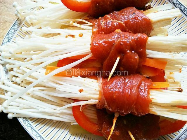 将一片腌好的牛肉摊平放入一小块金针菇，2丝胡萝卜丝、青笋丝和1丝红椒，小心卷起来，尽量卷紧实一些，接头处用牙签固定