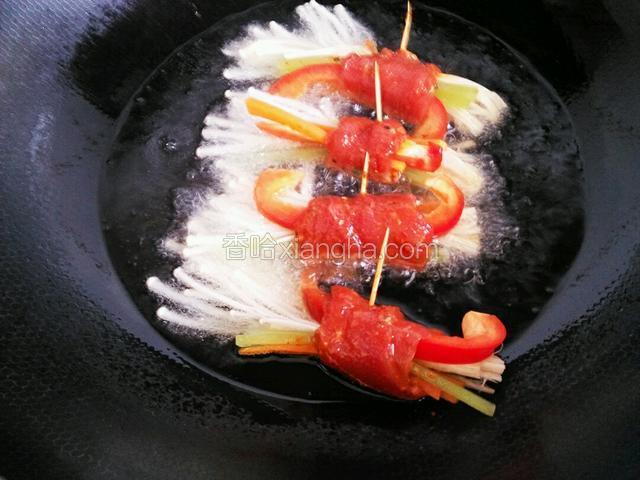 锅中放油，油温5成，将卷好的金针菇牛肉卷逐个放入油锅中炸1分钟捞起