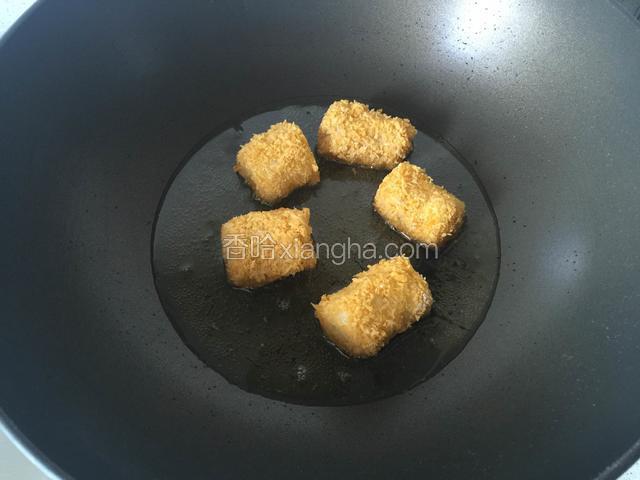 锅里倒入色拉油烧至八成热，把一段段蘸满面包糠的香蕉段放入油锅内炸透。